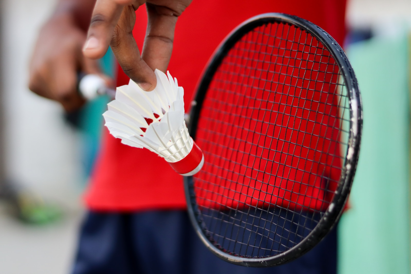 person holding red and black tennis racket