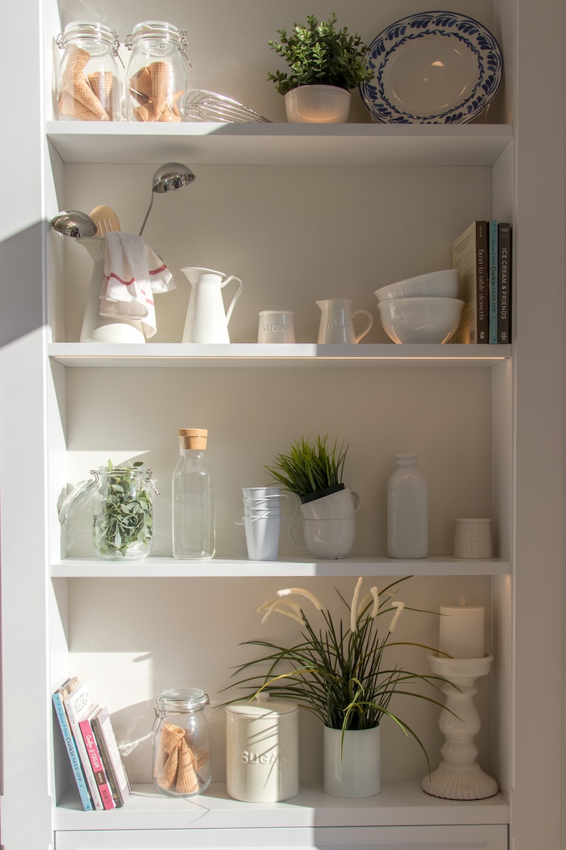 bowls and bottles in white wooden 4-layer shelf