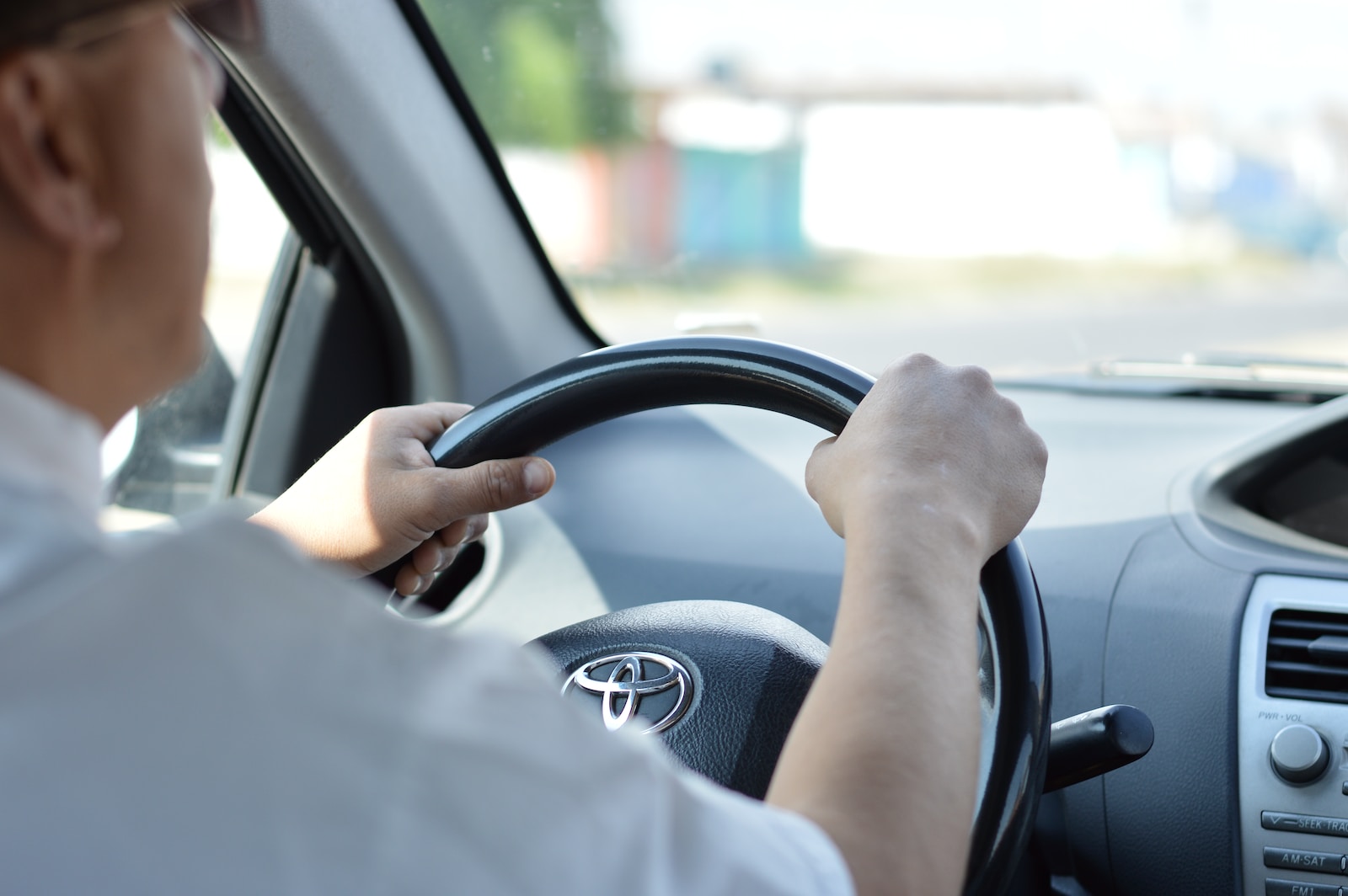 person in white long sleeve shirt driving car